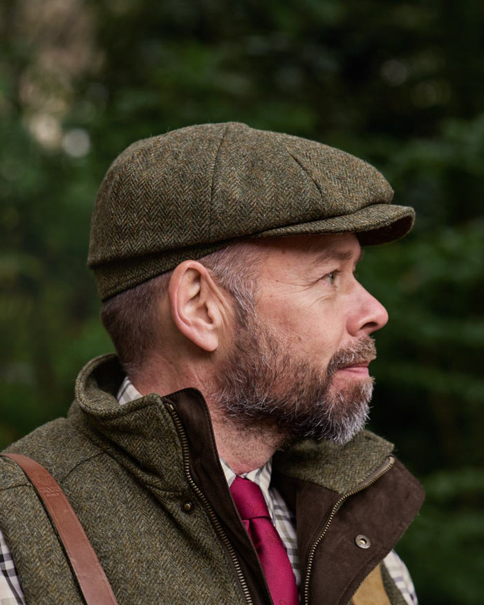 Forest Green Herringbone Coloured Harkila Kenmore Classic Baker Boy Cap on forest background #colour_forest-green-herringbone