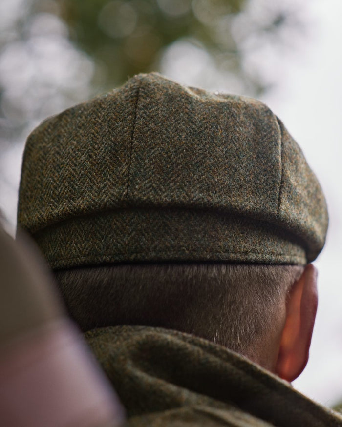 Forest Green Herringbone Coloured Harkila Kenmore Classic Baker Boy Cap on forest background #colour_forest-green-herringbone