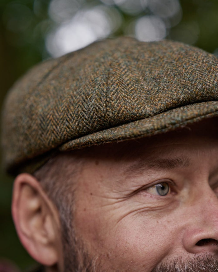 Forest Green Herringbone Coloured Harkila Kenmore Classic Baker Boy Cap on forest background #colour_forest-green-herringbone