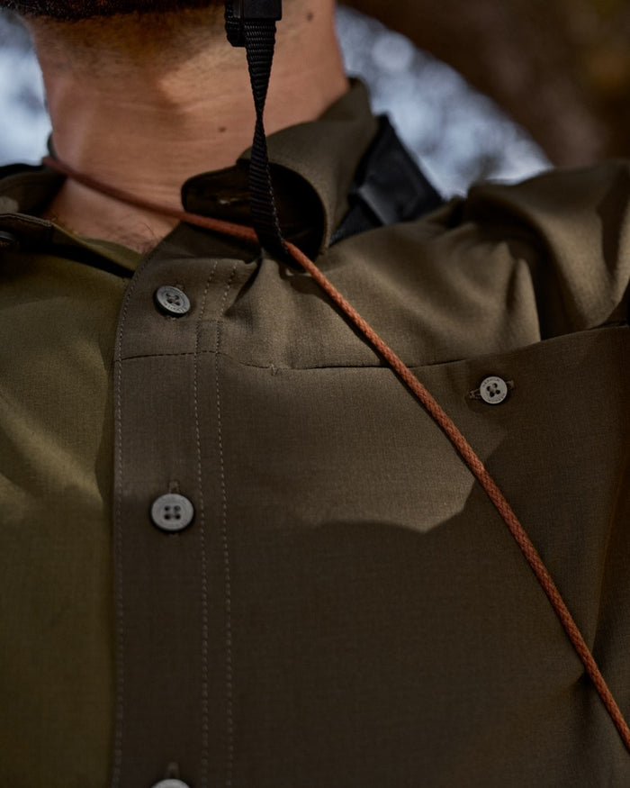 Dark Olive Willow Green Coloured Harkila Kenmore Cl. Flat Cap on forest background #colour_dark-olive-willow-green