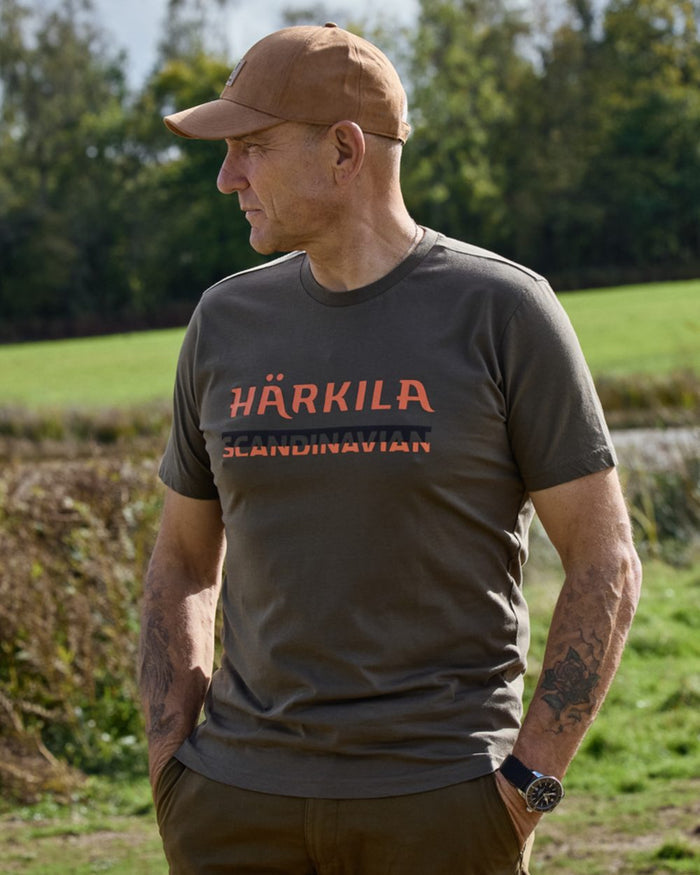 Grape Leaf coloured Harkila Mens Scandinavian Short Sleeve T-Shirt on forest background #colour_grape-leaf