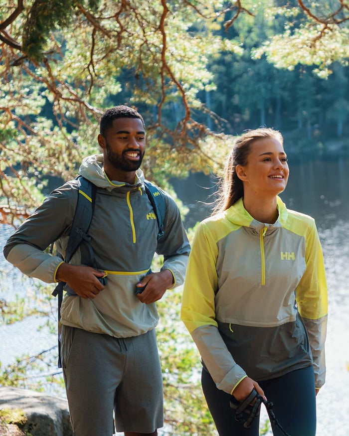 Sharp Green coloured Helly Hansen Womens Roam Wind Anorak on forest background #colour_sharp-green