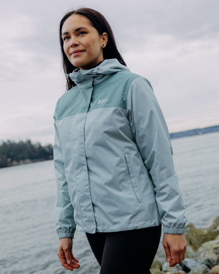 Green Mist coloured Helly Hansen Womens Vancouver Rain Jacket on sea background #colour_green-mist