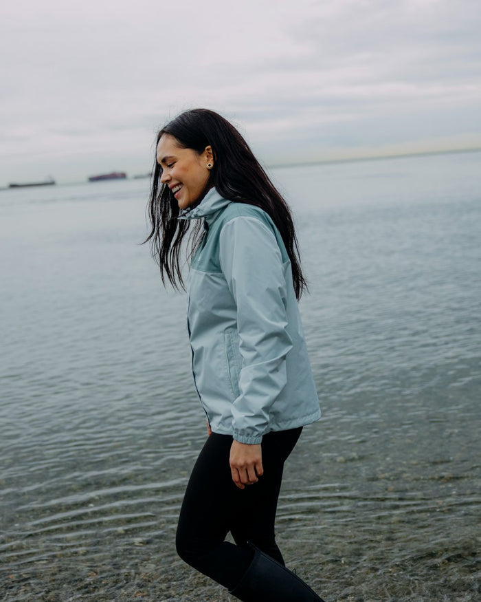 Green Mist coloured Helly Hansen Womens Vancouver Rain Jacket on sea background #colour_green-mist