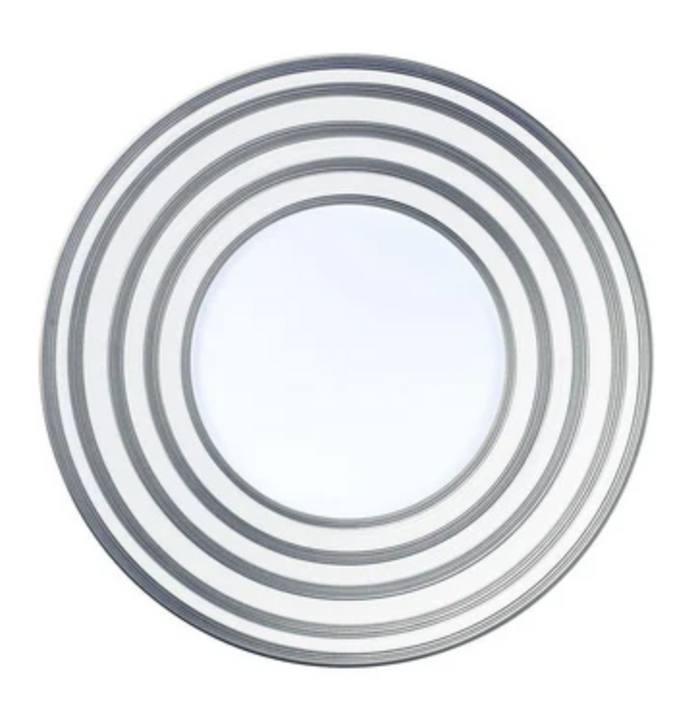 A modern round mirror from JL Coquet's Hemisphere Dinnerware Grey Stripes collection, inspired by Limoges porcelain and featuring four silver concentric rings for a symmetrical, elegant look.