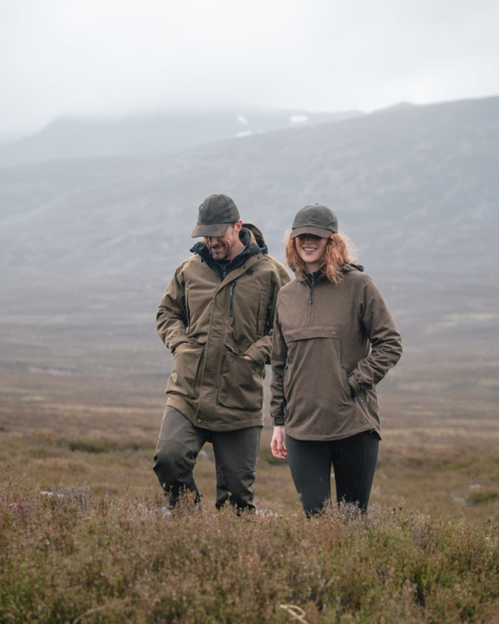 Dark Olive coloured Hoggs of Fife Mens Ardross Pro Waterproof Field Trousers on moorland background #colour_dark-olive