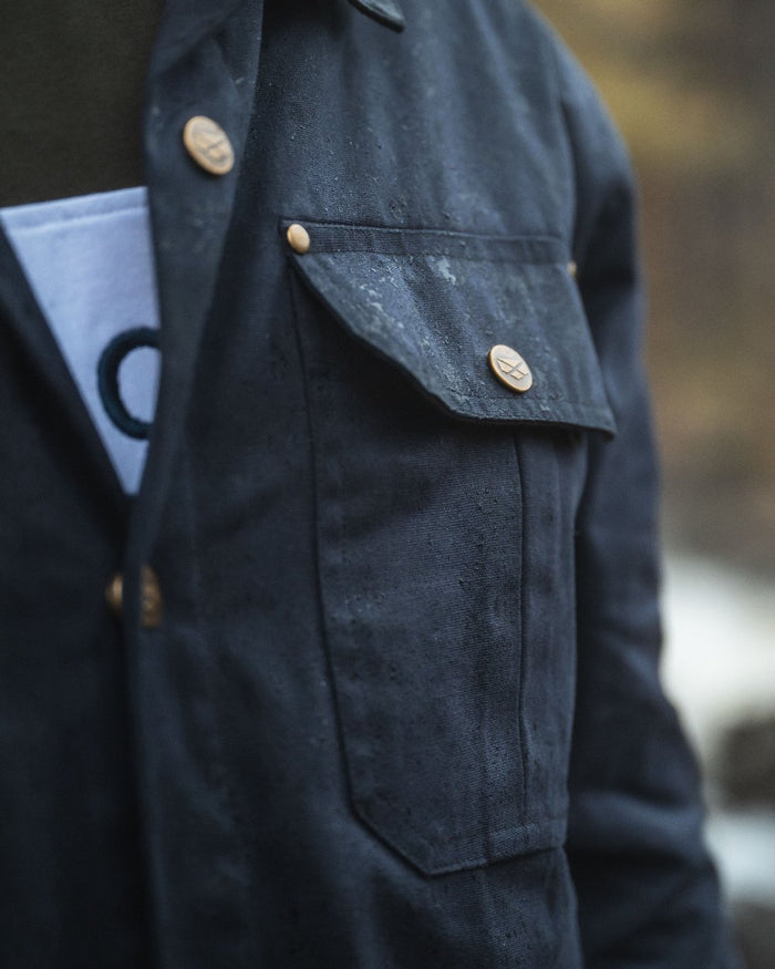 Midnight Navy Coloured Hoggs of Fife Mens Huntly Waxed Canvas Utility Overshirt on blurry background #colour_midnight-navy