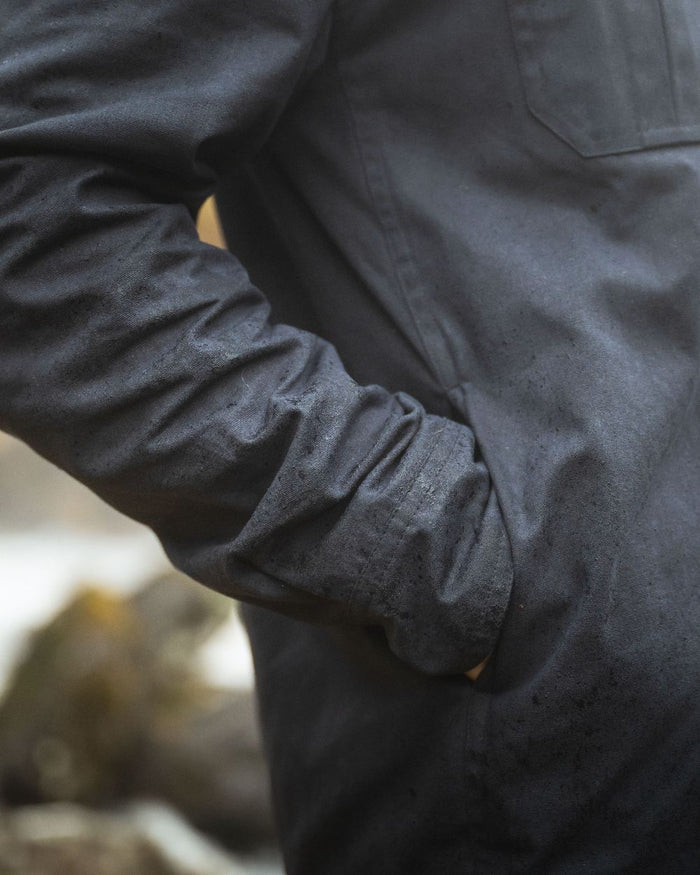 Midnight Navy Coloured Hoggs of Fife Mens Huntly Waxed Canvas Utility Overshirt on blurry background #colour_midnight-navy