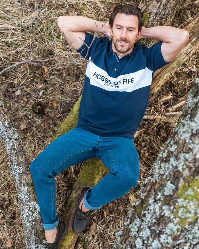 Navy Coloured Hoggs of Fife Mens Stewart Block Pique Polo Shirt on forest background #colour_navy