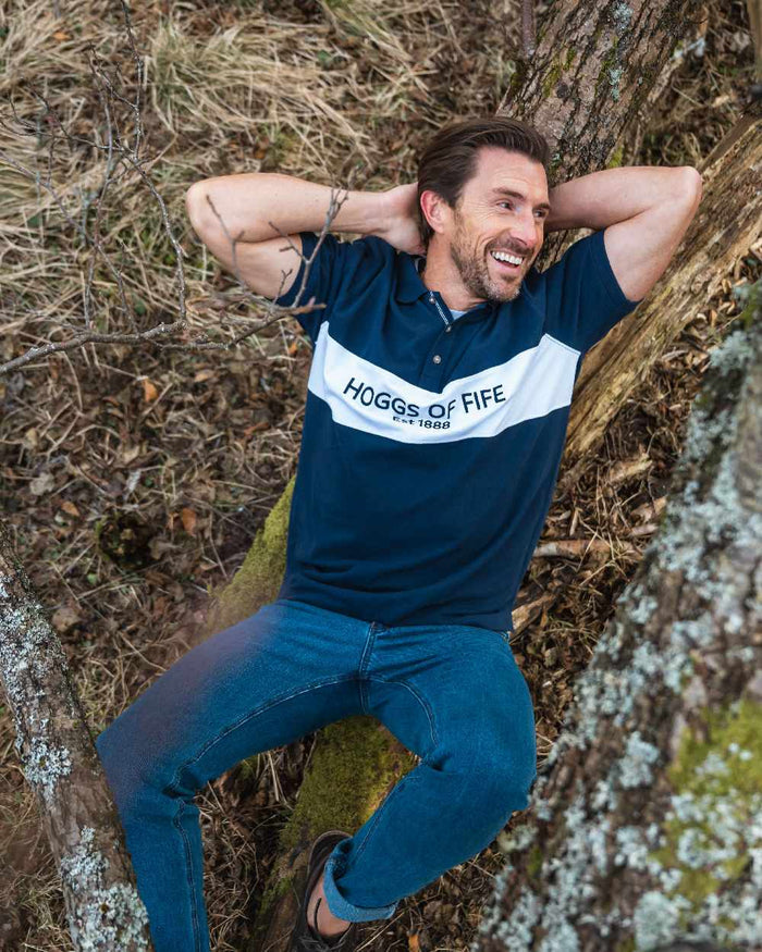 Navy Coloured Hoggs of Fife Mens Stewart Block Pique Polo Shirt on forest background #colour_navy