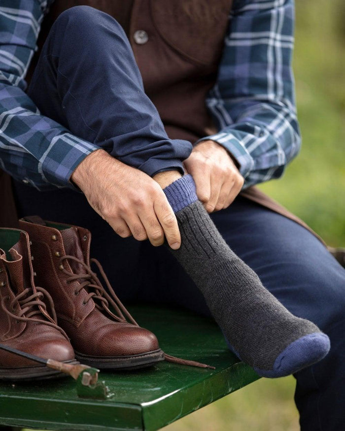 Charcoal St Andrews Blue coloured House of Cheviot Glen Technical Socks on blurry background #colour_charcoal-st-andrews-blue