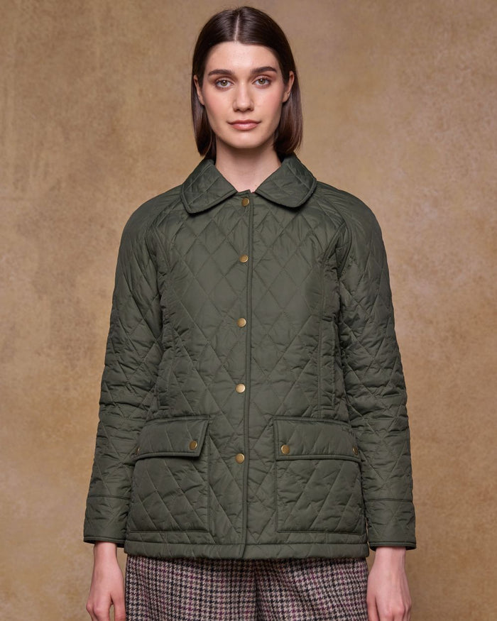 Olive coloured Jack Murphy Womens Molly Quilted Jacket on wall background #colour_olive