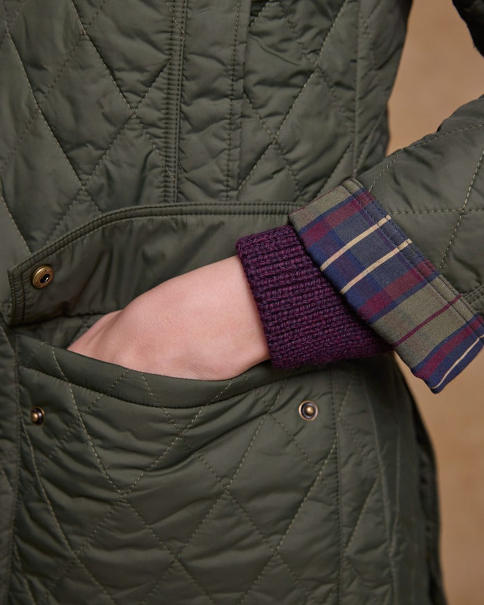 Olive coloured Jack Murphy Womens Molly Quilted Jacket on wall background #colour_olive