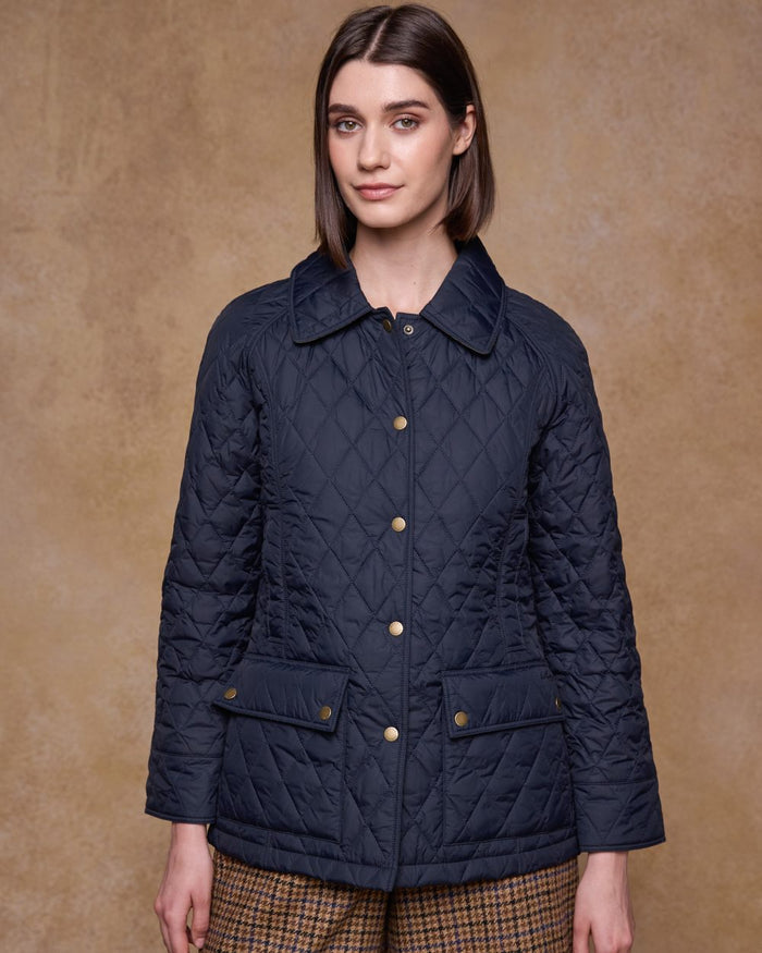 Navy coloured Jack Murphy Womens Molly Quilted Jacket on wall background #colour_navy