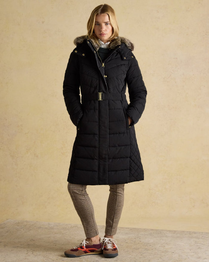 Black Coloured Joules Womens Aspen Long Showerproof Padded Coat on indoor background #colour_black