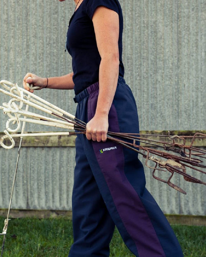 Navy coloured Kaiwaka Womens Stormforce Overtrouser on grassy background #colour_navy