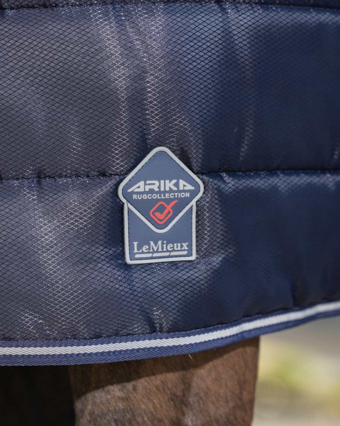 Navy coloured LeMieux Arika Stable-Tek 100g on outdoor background #colour_navy