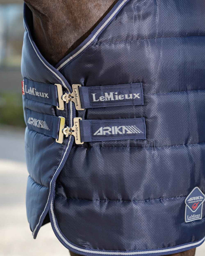 Navy coloured LeMieux Arika Stable-Tek 100g on outdoor background #colour_navy