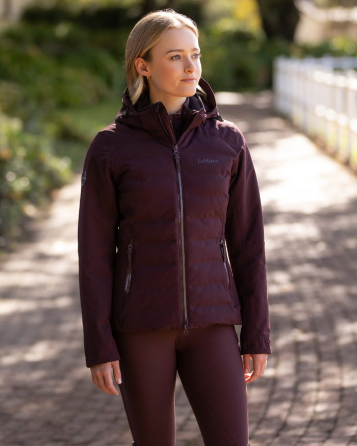 Damson coloured LeMieux Brooke Waterproof Hybrid Jacket on park background #colour_damson