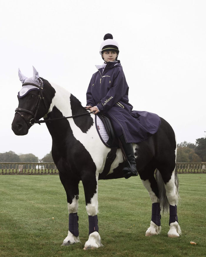 Lilac coloured LeMieux Pom Hat Silk on farm background #colour_lilac