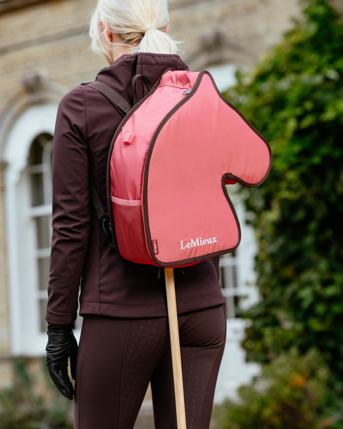 Cranberry coloured LeMieux Hobby Horse Carry Bag on outdoor background #colour_cranberry