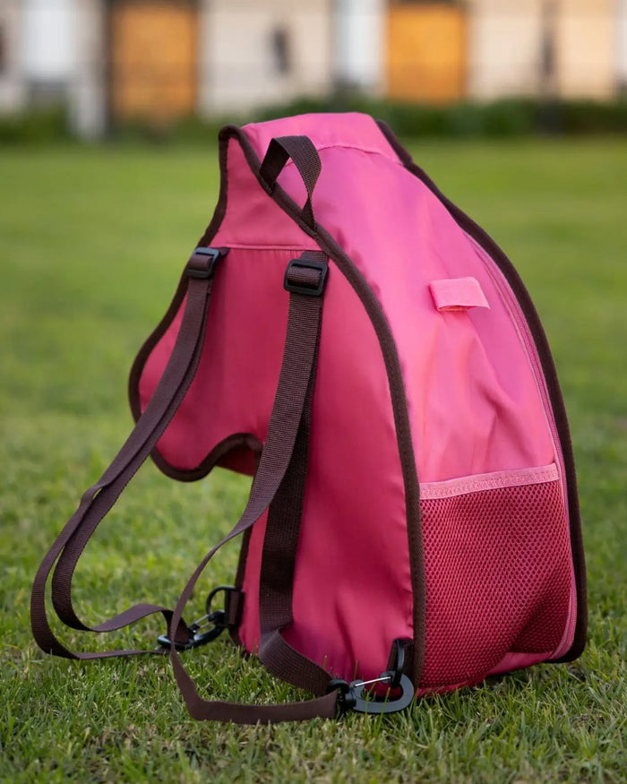 Cranberry coloured LeMieux Hobby Horse Carry Bag on garden background #colour_cranberry