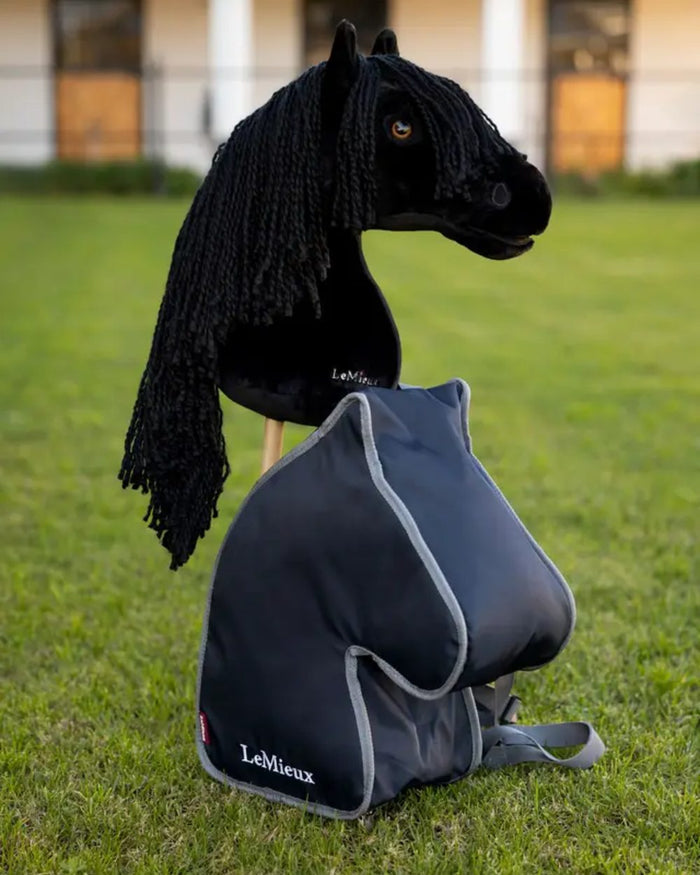 Navy coloured LeMieux Hobby Horse Carry Bag on garden background #colour_navy