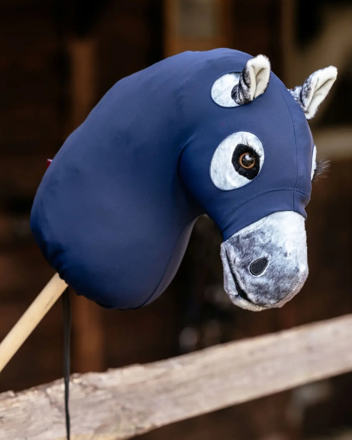 Navy coloured LeMieux Hobby Horse Clean Hood on blurry background #colour_navy