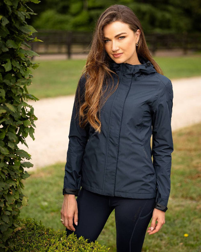 Navy coloured LeMieux Isla Short Waterproof Jacket on green background #colour_navy