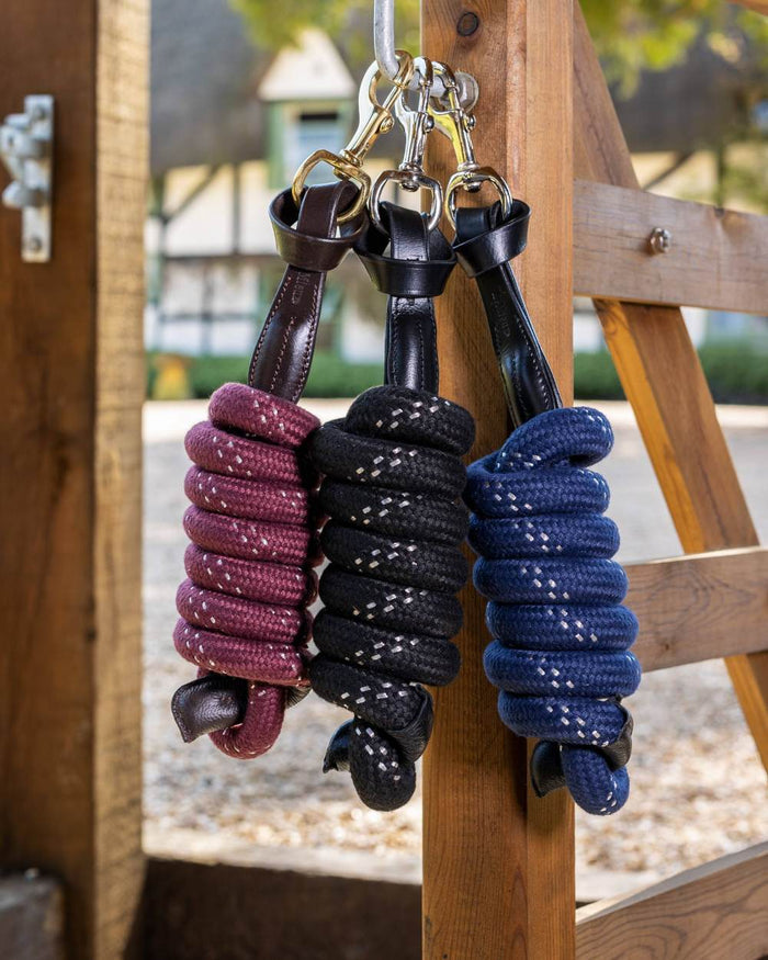 Burgundy coloured LeMieux Lasso Lead Rope on wooden background #colour_burgundy