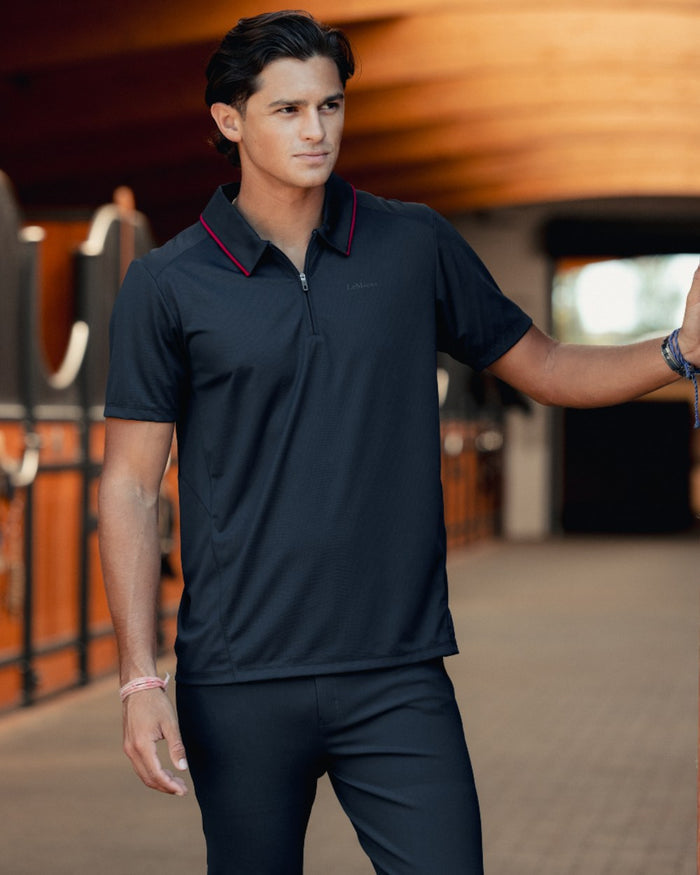 Black coloured LeMieux Mens Performance Polo T-Shirt on outdoor background #colour_black