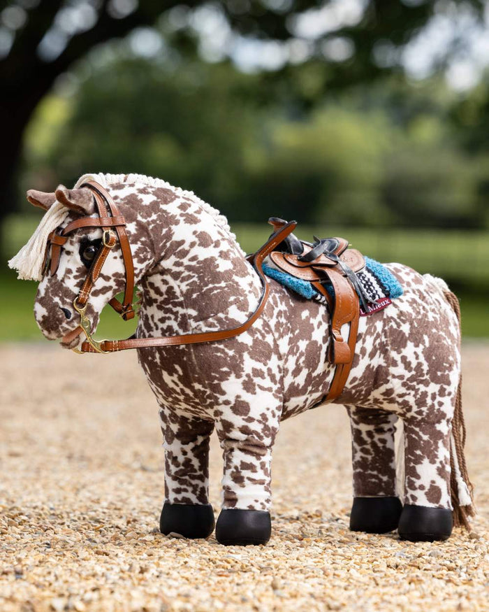 Tan coloured LeMieux Toy Pony Western Saddle on blurry background #colour_tan