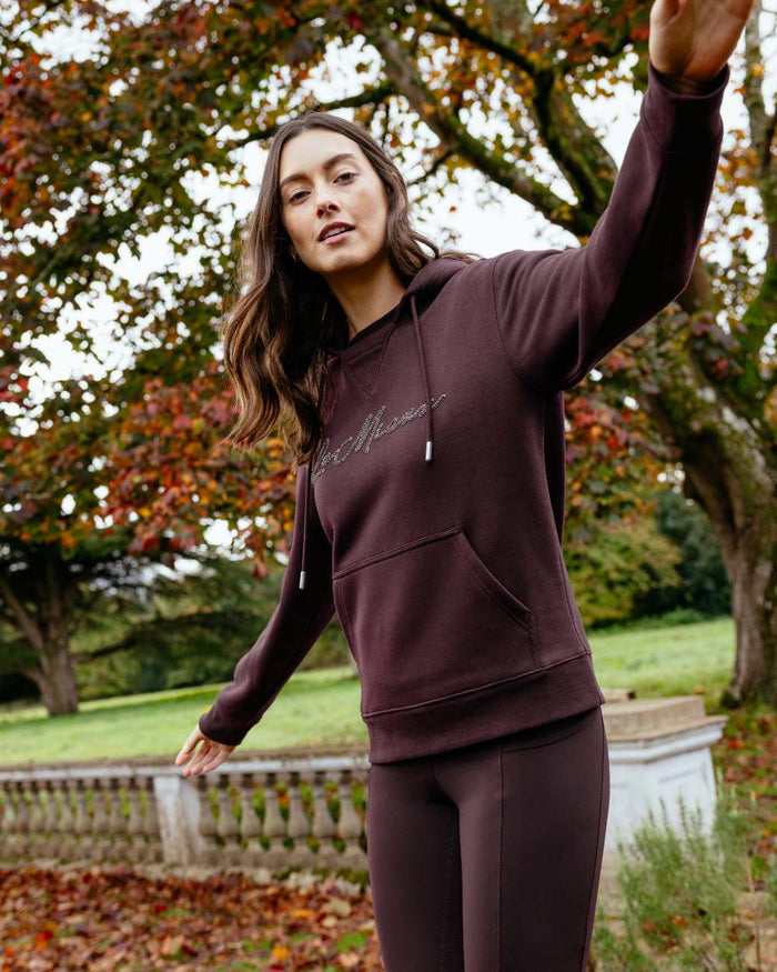 Damson coloured LeMieux Womens Elspeth Hoodie on garden background #colour_damson