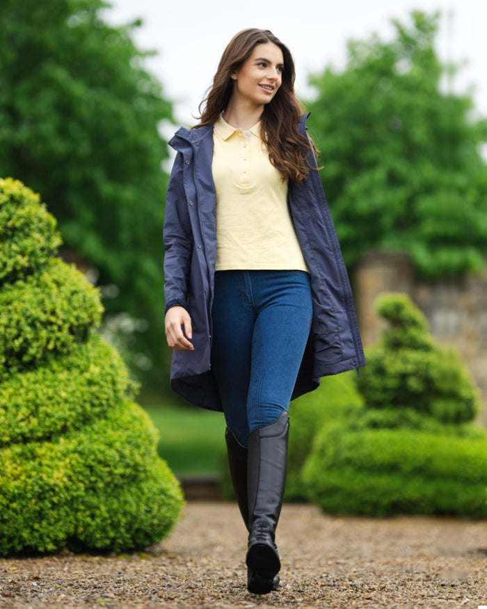 Dusk Blue coloured LeMieux Womens Grace Long Rain Jacket on backyard background #colour_dusk-blue