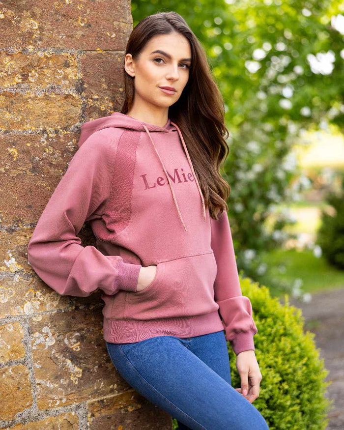 Peony coloured LeMieux Womens Nadine Hoodie on wall background #colour_peony