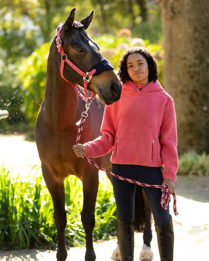 Cranberry coloured LeMieux Young Rider Avalon Hoodie on tree background #colour_cranberry
