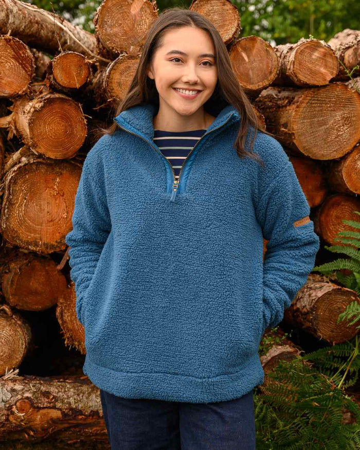 Teal coloured Lighthouse Ladies Coast Half Zip Fleece Sweater on wood background #colour_teal