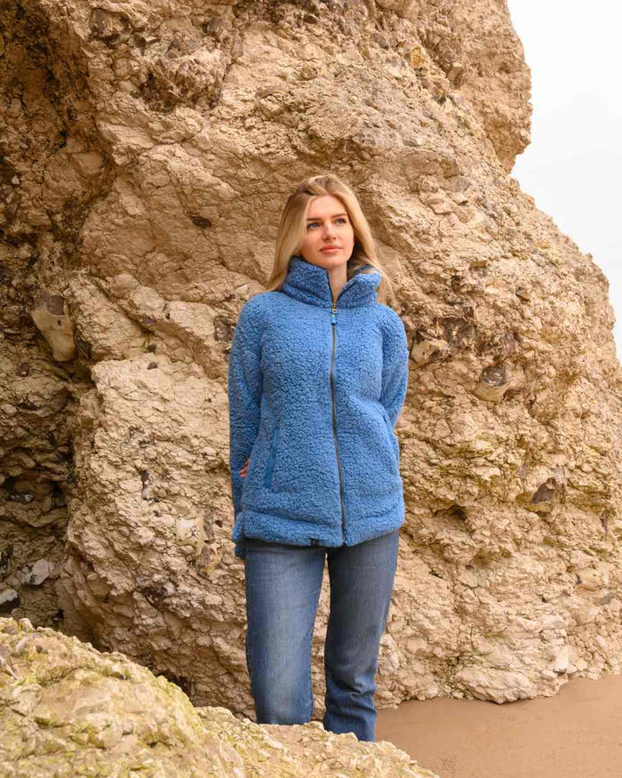 Marine Blue coloured Lighthouse Ladies Seashell Full Zip Sherpa Fleece on rock background #colour_marine-blue