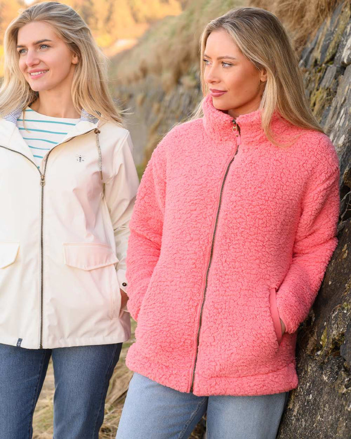 Sugar Coral coloured Lighthouse Ladies Seashell Full Zip Sherpa Fleece on rock background #colour_sugar-coral