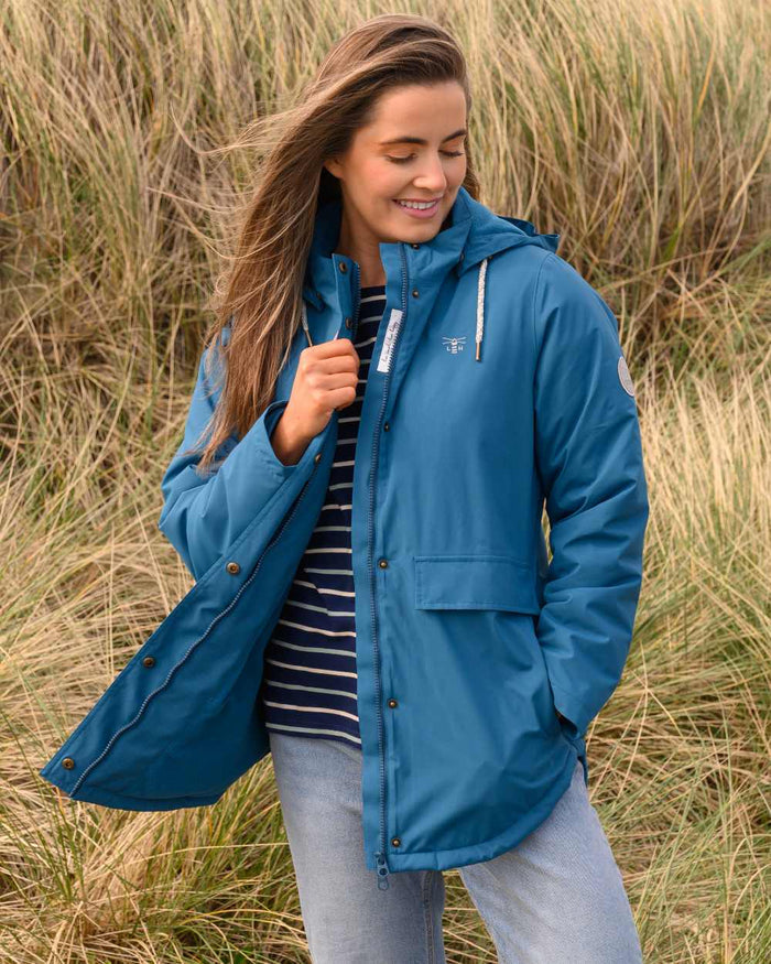 Teal coloured Lighthouse Ladies Tess Coat on grassy background #colour_teal