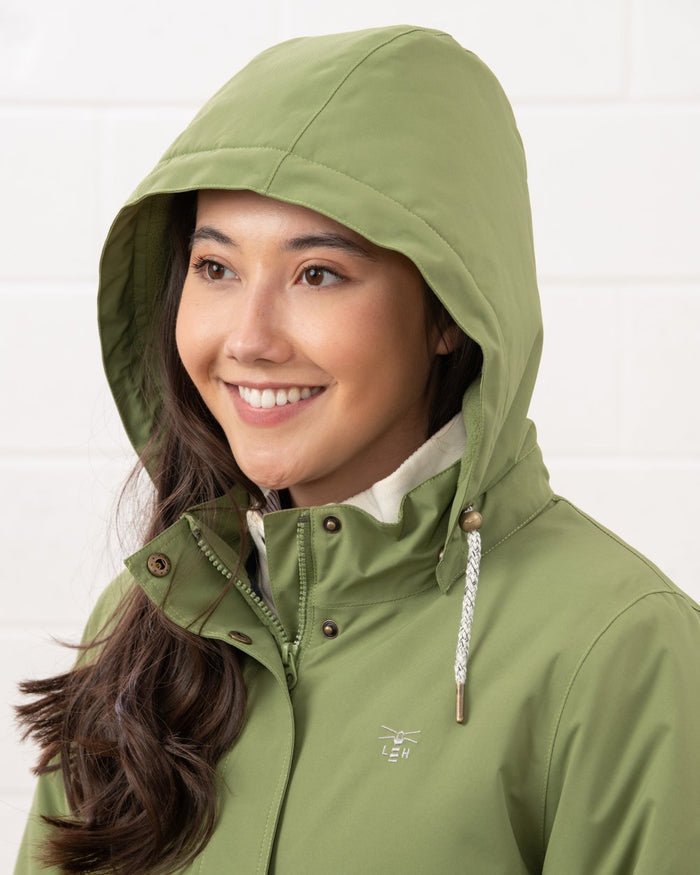 Sea Kelp coloured Lighthouse Ladies Tess Coat on wall background #colour_sea-kelp
