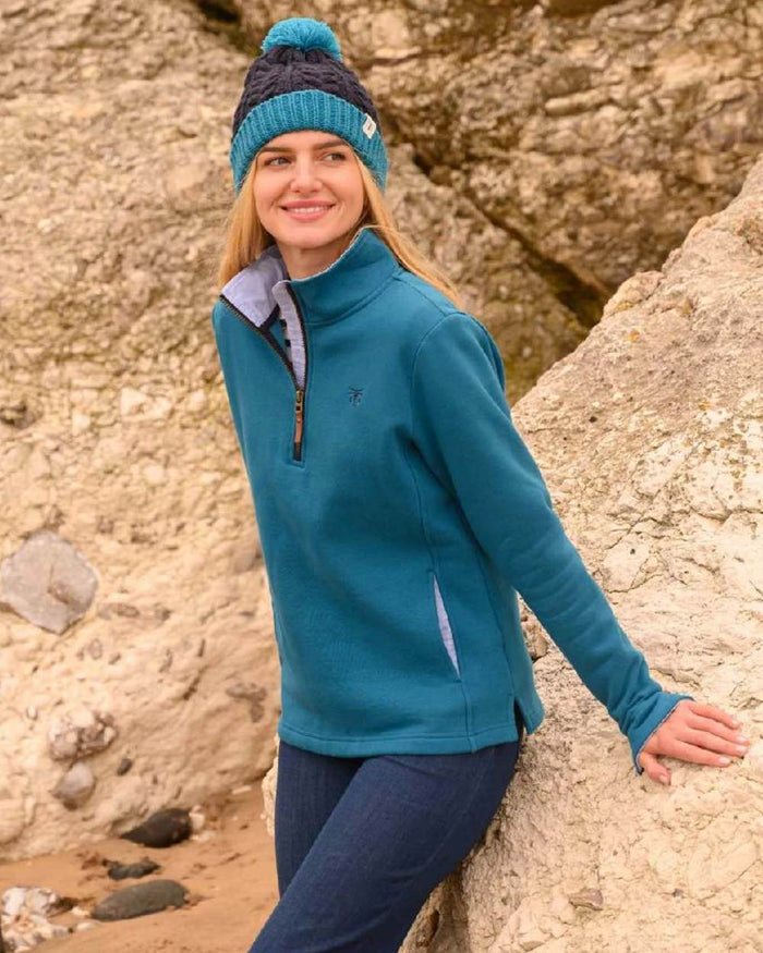 Teal coloured Lighthouse Shore Jersey Top on rock background #colour_teal