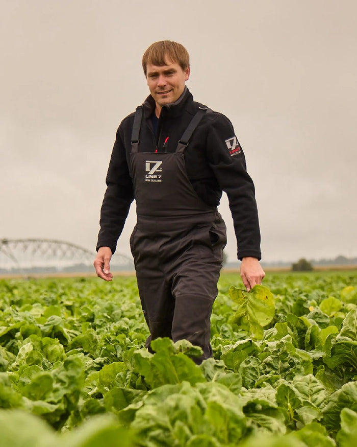 Black Coloured Line 7 Mens Storm Pro 20 Bib Pant V2 on farm background #colour_black