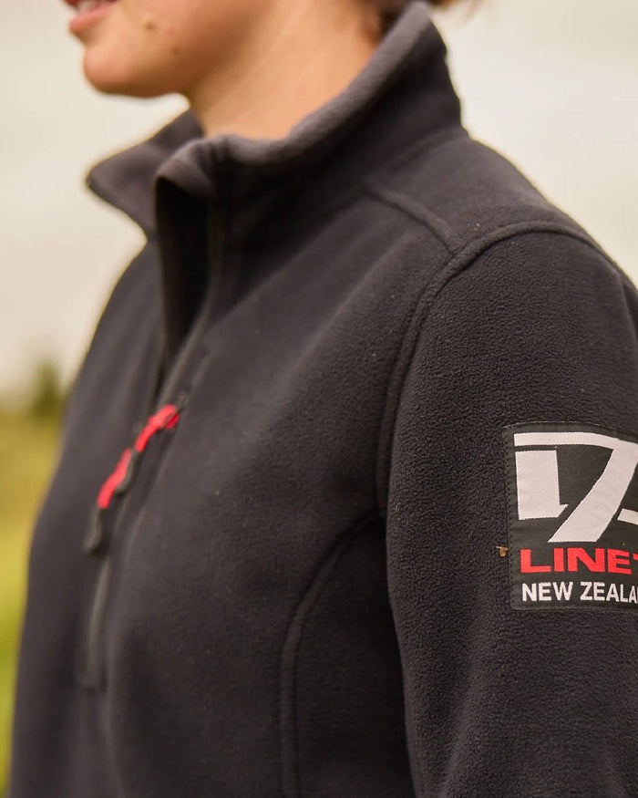 Black Coloured Line 7 Womens Territory Wind Pro Half Zip Fleece Jacket on blurry background #colour_black