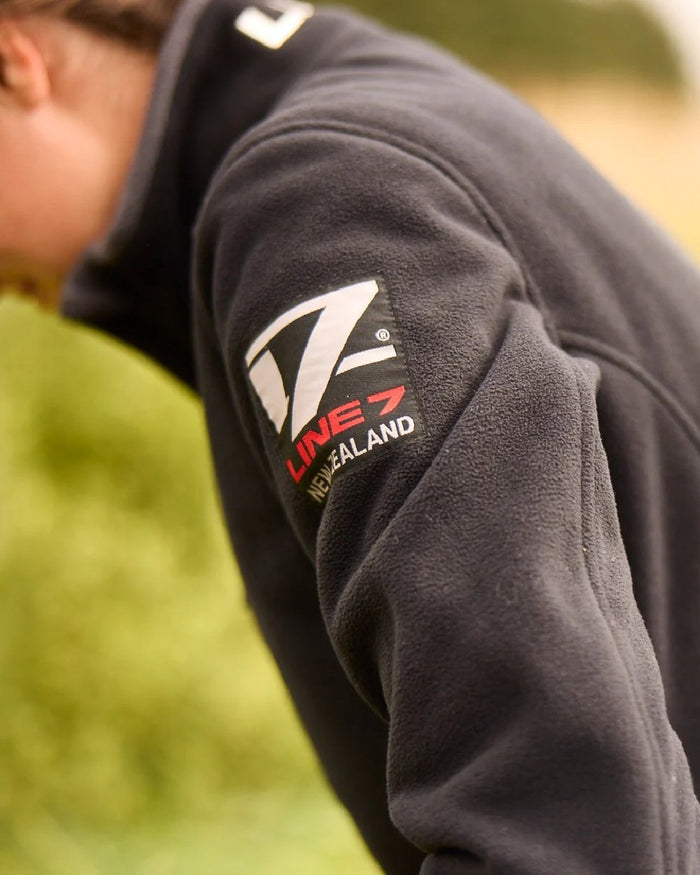 Black Coloured Line 7 Womens Territory Wind Pro Half Zip Fleece Jacket on blurry background #colour_black