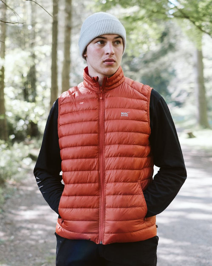 Burnt Orange Coloured Mac In A Sac Mens Synergy Gilet on forest background #colour_burnt-orange