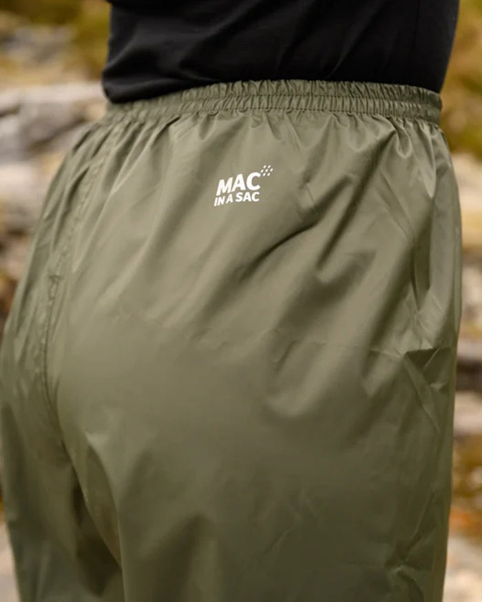 khaki coloured Mac In A Sac Origin Packable Waterproof Overtrousers on blurry background #colour_khaki