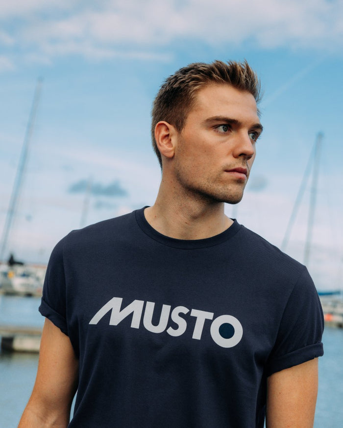 Navy Coloured Musto Logo Tee On A Sea Background 
#colour_navy
