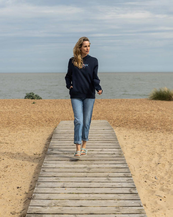 Navy Coloured Musto Womens 1964 Hoodie On A Beach Background #colour_navy