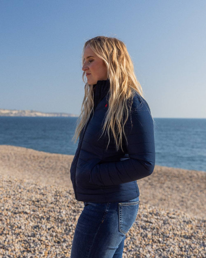 Navy Coloured Musto Womens Original Lite Puffer Jacket on beach background #colour_navy